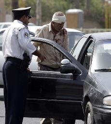 8月19日，在伊拉克首都巴格達財政部附近，一名交警幫助一名在爆炸襲擊中受傷的男子。新華社/路透